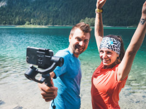 Gimbal zum Filmen mit dem Smartphone, Pärchen am Eibsee in Bayern, Zugspitze, Alpen, Selfie, Filmen, Videodreh, Frau mit Stirnband